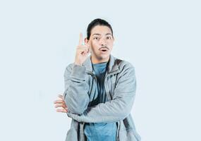 Surprised guy pointing a promotion up isolated. Surprised asian man pointing a discount up on isolated background photo