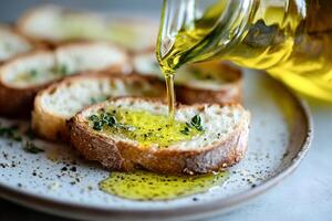 Olive oil drizzled on rustic bread slices with fresh herbs and black pepper photo