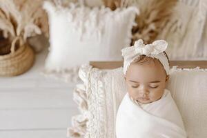 Sweetly swaddled newborn baby girl resting peacefully in a cozy, natural setting with soft textures and decor photo