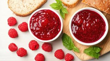 Delicious raspberry jam served in bowls alongside fresh bread and raspberries. photo
