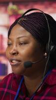 Vertical Smiling call center agent assisting customers through digital communication channels. Customer support employee using computer to have conversation with client in live chat, camera A video