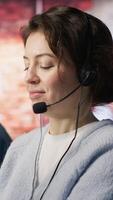 Vertical Friendly customer support workers respond to customers inquiries about products or services. Cheerful call center agent in office providing accurate and satisfactory information to customers, camera A video