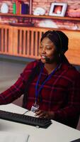 Vertical Call center workers track shipments using artificial intelligence, looking at computer screen. Customer center agent uses software to locate clients packages and provide status updates using AI video