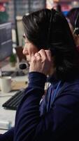 vertical técnico Apoio, suporte especialista dentro ligar Centro escritório fazendo solução de problemas, Falando dentro fone de ouvido microfone. isto trabalhador fixação cliente conectividade emitir, falando dentro fones de ouvido microfone, Câmera b fechar acima video