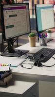 Vertical CSM system interfaces on computer monitors in empty customer service workplace and call center audio headsets. Customer service management software UI on PC displays and headphones with mic on desk video