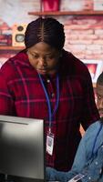 Vertical Portrait of smiling multiethnic call center agents helping customers regain access to accounts. Happy multiracial workers in diverse customer center assisting clients needing help, camera A video
