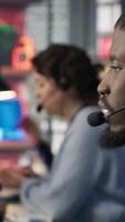 Vertical Call center employee using artificial intelligence chatbot to provide multilingual support to customers. Customer support operator leveraging AI tools to translate clients interactions, camera A video