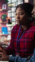 Vertical Call center coworkers in office helping customers regain access to accounts using AI, resetting passwords. Colleagues in customer center assisting clients needing help using artificial intelligence video