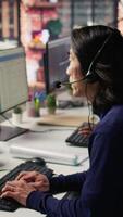 vertical com experiência ligar Centro empregado ouvindo para cliente inquéritos e reclamações. ásia Senior cliente serviço representante ajudando clientes com problemas relacionado para produtos ou Serviços, Câmera b video