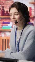 Vertical Call center employee handling customer complaints, offering helpful solutions to their concerns. Customer service agent providing helpful information related to products or services, camera A video