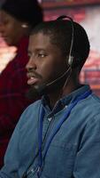 Vertical Call center agent helping customers regain access to accounts, diagnosing problems. Customer center staff member assisting clients needing help, providing accurate information, camera A video