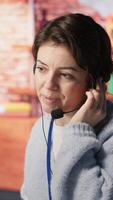 Vertical Call center agent helping customers regain access to accounts, resetting passwords. Employee in customer center workspace assisting clients needing help, providing helpful solutions, camera A video