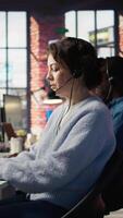 vertical cliente Apoio, suporte trabalhadores ajudar clientes com técnico problemas de diagnóstico problemas. ligar Centro agentes vestindo fones de ouvido dentro escritório fazendo desescalada e queixa resolução video