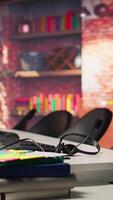 Vertical Audio equipment headset with mic used in customer support job workspace, close up. Headphones with microphone on call center company office desk used by workers to discuss with customers video