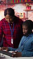 Vertical Portrait of smiling multiethnic call center agents helping customers regain access to accounts. Happy multiracial workers in diverse customer center assisting clients needing help, camera B video