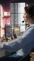 vertical ligar Centro agente tratamento de entrada chamadas, ajudando clientes com inquéritos, atualizando conta registros e encontro desempenho Métricas dentro escritório ambiente, Câmera b fechar acima video
