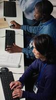 vertical ligar Centro colegas de trabalho dentro diverso escritório ajudando clientes, aéreo tomada. trabalho em equipe empregados dentro cliente Centro área de trabalho ajudando clientes precisando Socorro reiniciando senha video