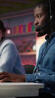 Vertical Manager supervising technical support specialist in call center office doing troubleshooting. Supervisor overseeing work done by IT worker fixing customer connectivity issue, camera B video