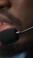 Vertical Extreme closeup of call center agent using audio headset microphone to provide guidance to customers. Customer center worker using headphones mic to walk clients through technical solutions, camera A video