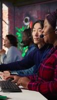 Vertical Experienced call center team leader assisting employee and drinking coffee in office. Asian account manager doing teamwork with colleague, enjoying beverage in workplace, camera B video