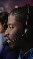 Vertical Call center agent providing support, handling clients complaints, speaking in audio headset mic. Employee dealing with unsatisfied customers, talking in headphones mic, camera B extreme close up video