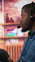 Vertical Call center manager supervising agent providing step by step guidance to customers. Customer center supervisor overseeing work done by employee walking clients through technical solutions, camera A video
