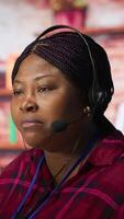 Vertical Customer center employee gesturing loud colleague to quiet down during conversation with client. Call center worker upset by noises in office while talking to customers using headphones mic, camera A video