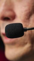 Vertical Closeup of technical support specialist in call center office doing troubleshooting, speaking in headset mic. IT worker fixing customer connectivity issue, talking in headphones microphone, camera A video