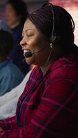 Vertical Friendly account manager in office maintaining strong client relationships to generate leads. Cheerful African american employee talking with customer, to identify new sales opportunities, camera A video
