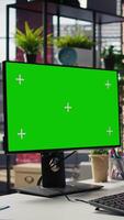 Vertical Call center worker solving customers issues using green screen PC. Customer support staff member in front of chroma key computer display using headset to talk with clients, camera B video