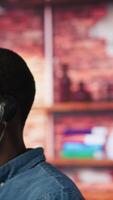 Vertical Call center employees wearing headset assisting customers in office. Workers doing customer support, communicating with clients in telephone call, providing service, camera A close up video