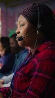 Vertical IT support expert at PC in call center office troubleshoots errors to minimize downtime. Tech support agent at desk writing code, maintaining technical systems and infrastructure, camera B video