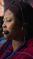 Vertical Call center agent listening to customer needs, providing step by step guidance. Customer center worker manages incoming and outgoing calls, walking clients through technical solutions, camera A video