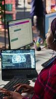 Vertical Call center employee using AI chatbot at office desk to reply to common customer queries, close up. Customer service staff member at work generates automated responses to clients using AI, camera B video