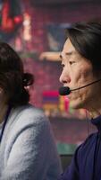 Vertical Call center manager supervising work done by agent helping customers regain access to accounts. Customer center supervisor overseeing employee assisting clients needing help, camera A video