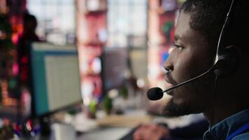 Call center agent using audio headset microphone to provide guidance to customers. Customer center worker using headphones mic to walk clients through technical solutions, camera B extreme close up video