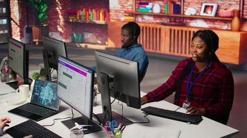 Call center workers track shipments using artificial intelligence, looking at computer screen. Customer center agent uses software to locate clients packages and provide status updates using AI video