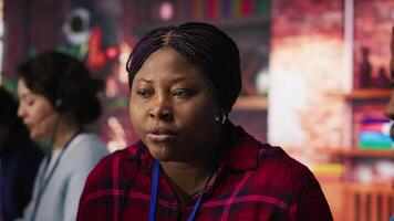 Call center coworkers in office helping customers regain access to accounts, resetting passwords. African american colleagues in customer center assisting clients needing help, camera A video