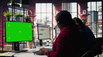 Call center agents tracking shipments in office using green screen computer. Customer center workers use chroma key PC to locate clients packages and provide status updates, camera B video