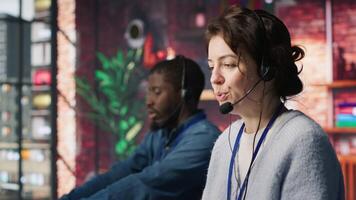 Joyous call center agent providing step by step guidance to resolve customers concerns. Happy customer center worker diagnosing problems, walking clients through technical solutions, camera A video