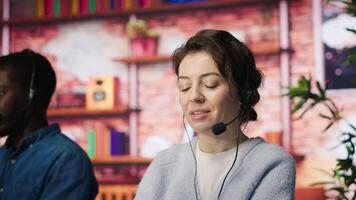 Customer support employees listening to clients issues. Teamworking call center agents in front of PC in office using headset mic to provide helpful solutions, solving customers concerns, camera A video