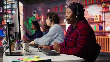 Smiling call center agent assisting customers through digital communication channels. Customer support employee using computer to have conversation with client in live chat, camera B video
