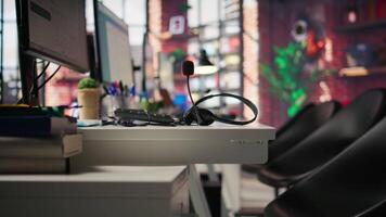 Headphones with microphone on call center office desk used by workers to speak with customers. Audio headset with mic used in customer support job workplace to talk with clients, close up video