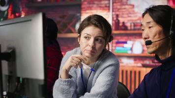 Call center team leader supervising agent helping customers regain access to accounts and devices. Customer center manager overseeing intern assisting clients needing help resetting password, camera A video