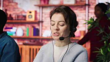 Happy call center employee working on PC, doing account management in office. Cheerful customer support agent handling inbound calls, assisting customers with inquiries, camera A close up video