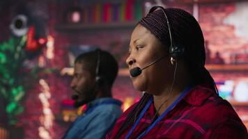 Smiling call center employee handling customer concerns, doing complaint resolution. Persuasive customer service agent contacts clients to inform them about new products, doing upselling camera A video