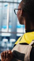 Vertical Industry 4.0 industrial plant expert controlling automated machinery using tablet, ensuring workflow continuity. Employee in smart factory manages robotic arms and conveyor belts with device, camera A video