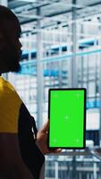 Vertical Worker using green screen laptop in smart factory, collecting and analyzing data. Expert using tracking software on chroma key notebook in industrial plant equipped with advanced sensors, camera A video