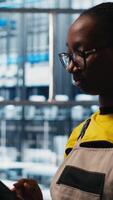 Vertical Worker using tablet in smart factory, collecting and analyzing data. Expert using tracking software on device in industry 4.0 industrial plant equipped with advanced sensors, camera A close up video