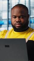 Vertical Happy engineer using laptop in industry 4.0 industrial plant to install machinery, conducting thorough testing. Cheerful robotics technician using notebook in smart factory calibrating IoT sensors video